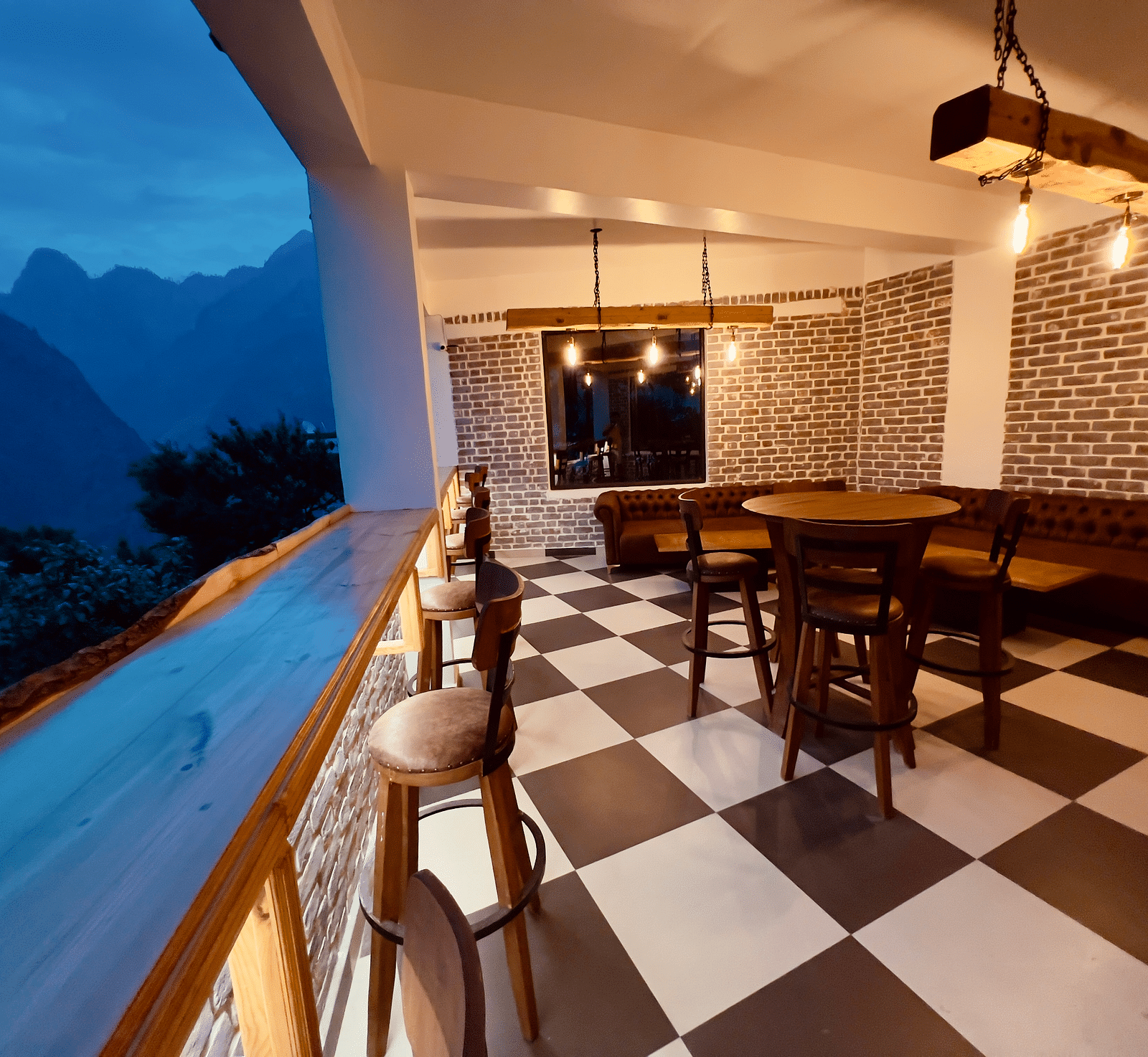 image of the alpenrose restaurant with black and white tiles overlooking at the amzing mountain views in the late evening - the tattva boutique resort 