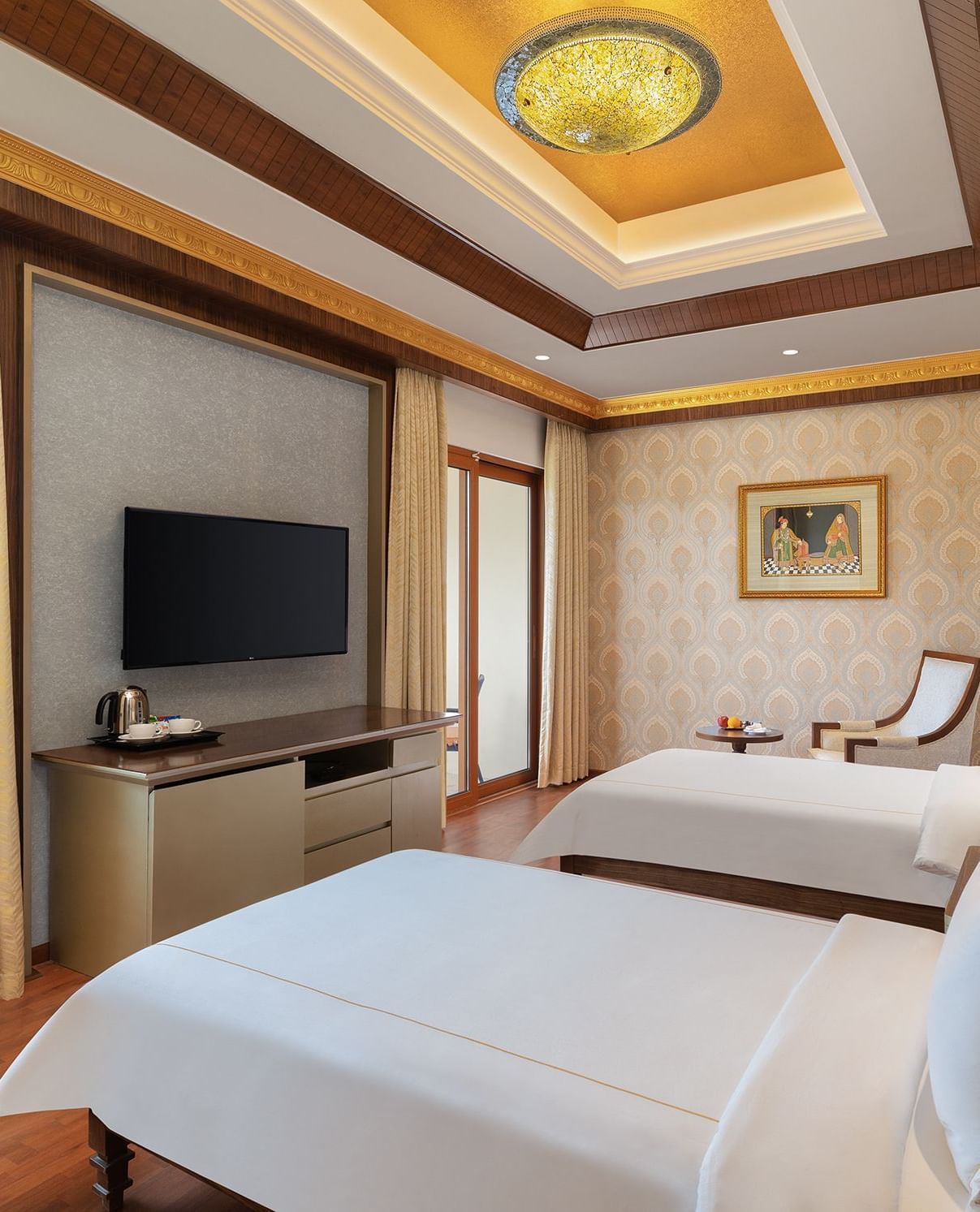A cosy bedroom with twin beds, large windows, and a scenic outdoor view – Kaldan Samudra, one of the top ECR resorts