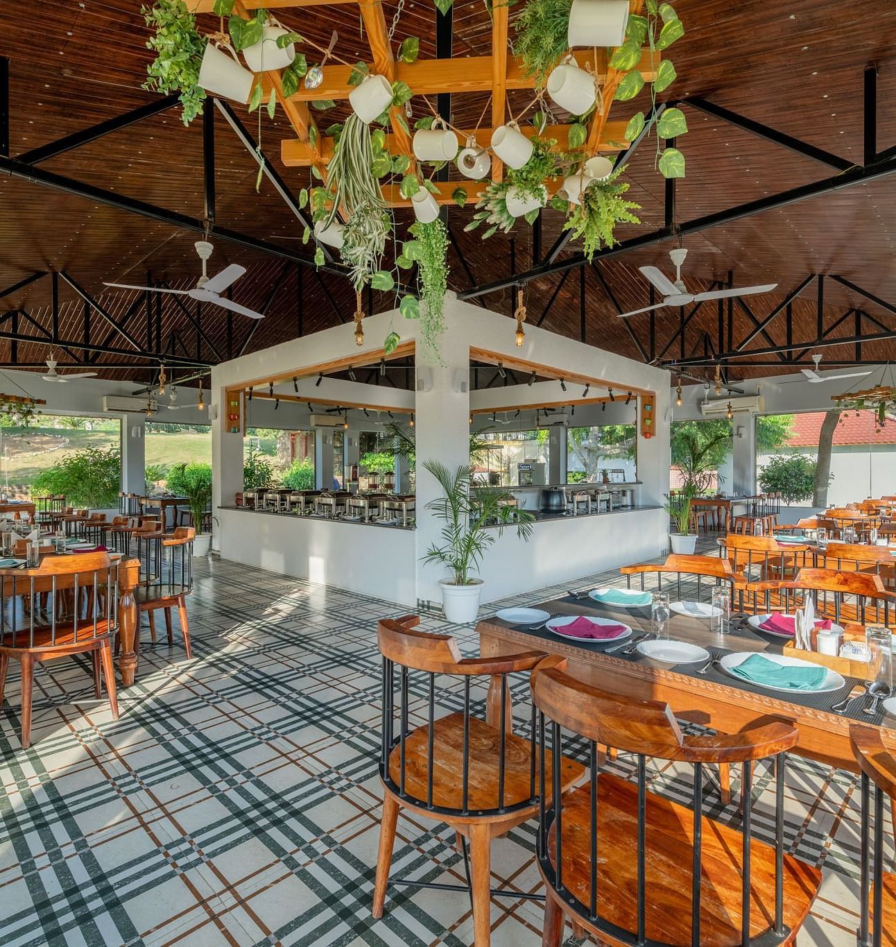 A dining area with wooden tables and chairs, complemented by ceiling fans at Valley by Grassfield. 