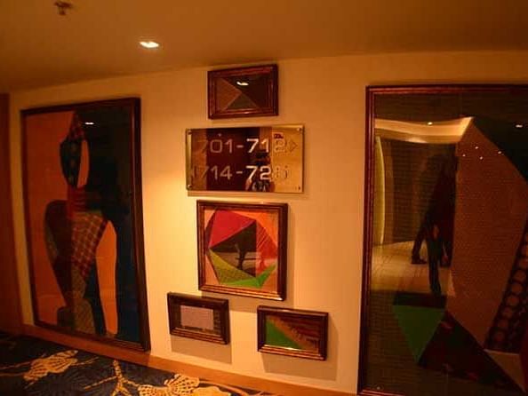 An image of a lobby wall where multiple images are hung with the room number signboard is also mounted