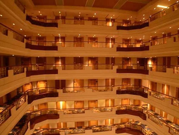 Interior view of the hotel with corridors illuminated by warm yellow lights.
