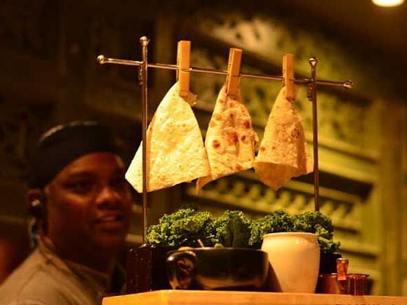 A close up shot of a beautifully presented food platter and in the background a man can be seen