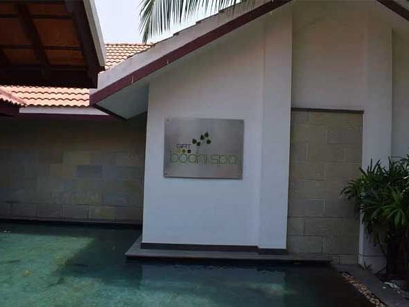 An exterior view of a spa featuring a water body in the foreground.