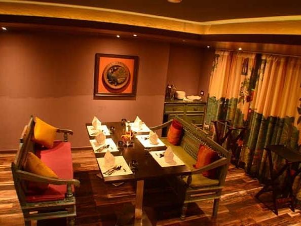 An image of a dining area featuring chairs and tables in a warm lit ambience