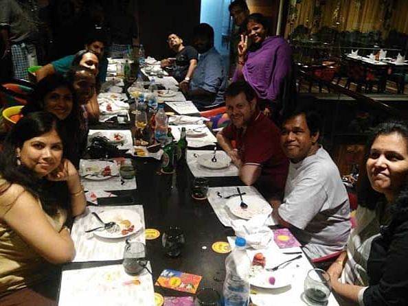 An image of group of people posing for a picture at the restaurant.