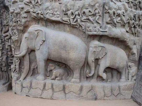 An image of intricately carved elephants on a large ancient stone.