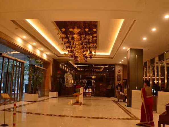 An image of a lobby space with a fancy ceiling emitting warm yellow light.