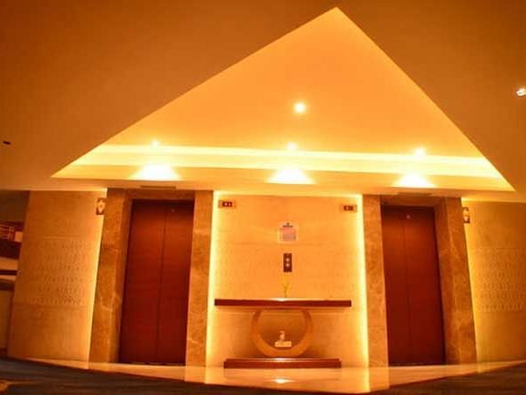 An image showing the entrance of two elevators with a stand in the centre.