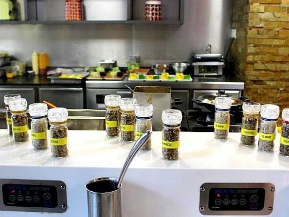 An image of glass spice jars placed on a counter top in a kitchen