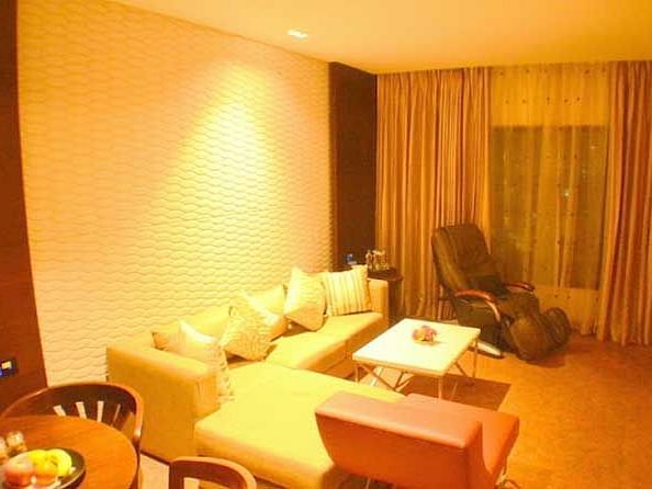 A living space featuring a long sofa adorned with multiple pillows.