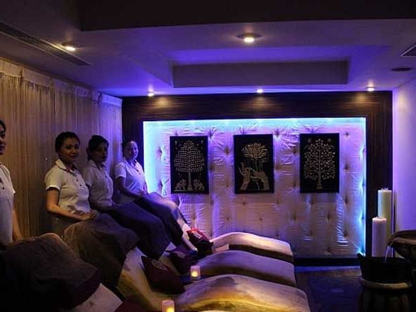 An image of a spa which is dimly lit where four masseuse standing