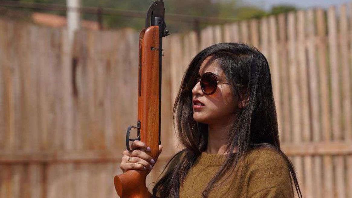 A woman holding a rifle for a shooting game at Ravishing Retreat 