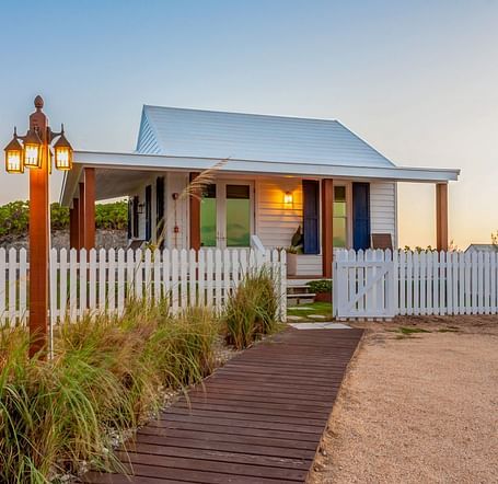 Entrance path leading to Hill Top Cottage at Abaco Inn with a picket fence and lantern.