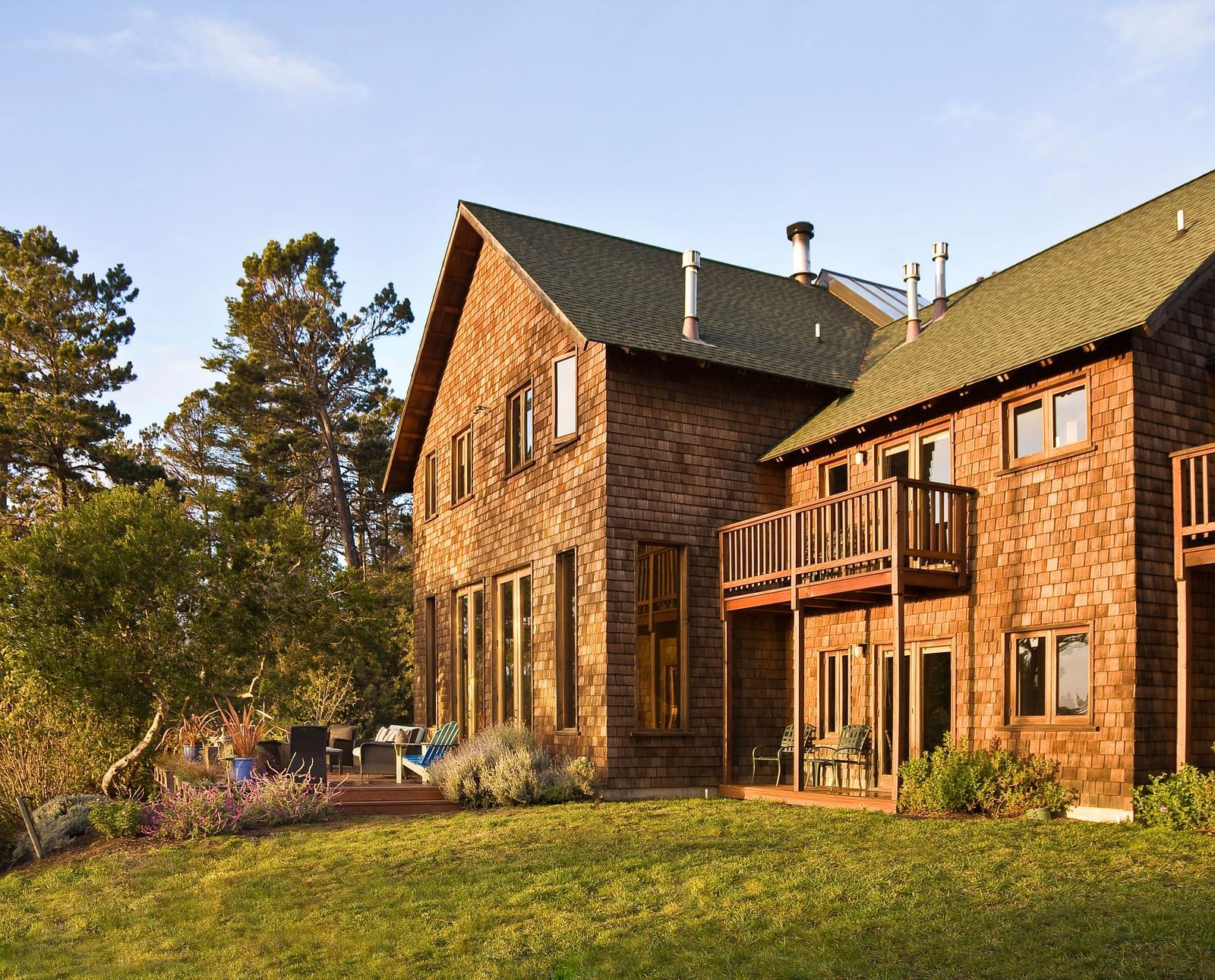 The rear view of Brewery Gulch Inn & Spa with a well manicured lawn and lush green trees