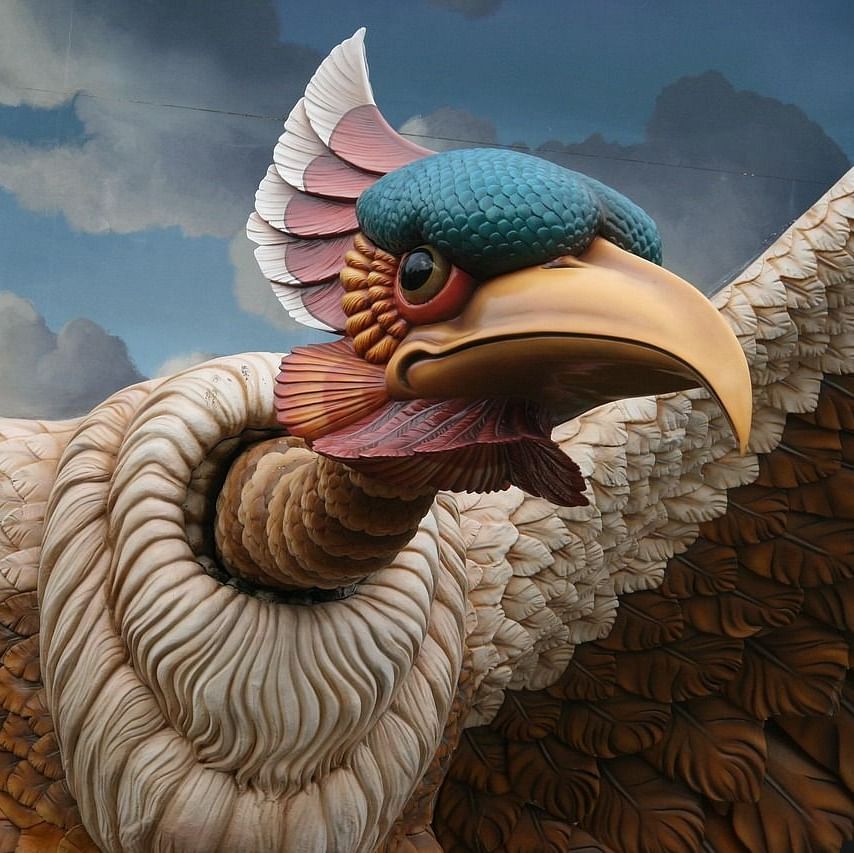 Sculpture of a large bird-like mythical creature with a fierce expression.