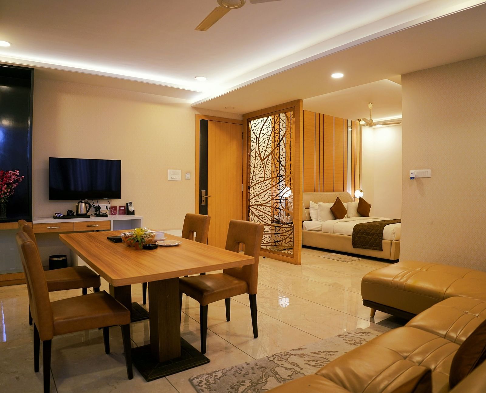 A modern living space featuring a dining area and a view into the bedroom - TGI Insignia, Bhopal