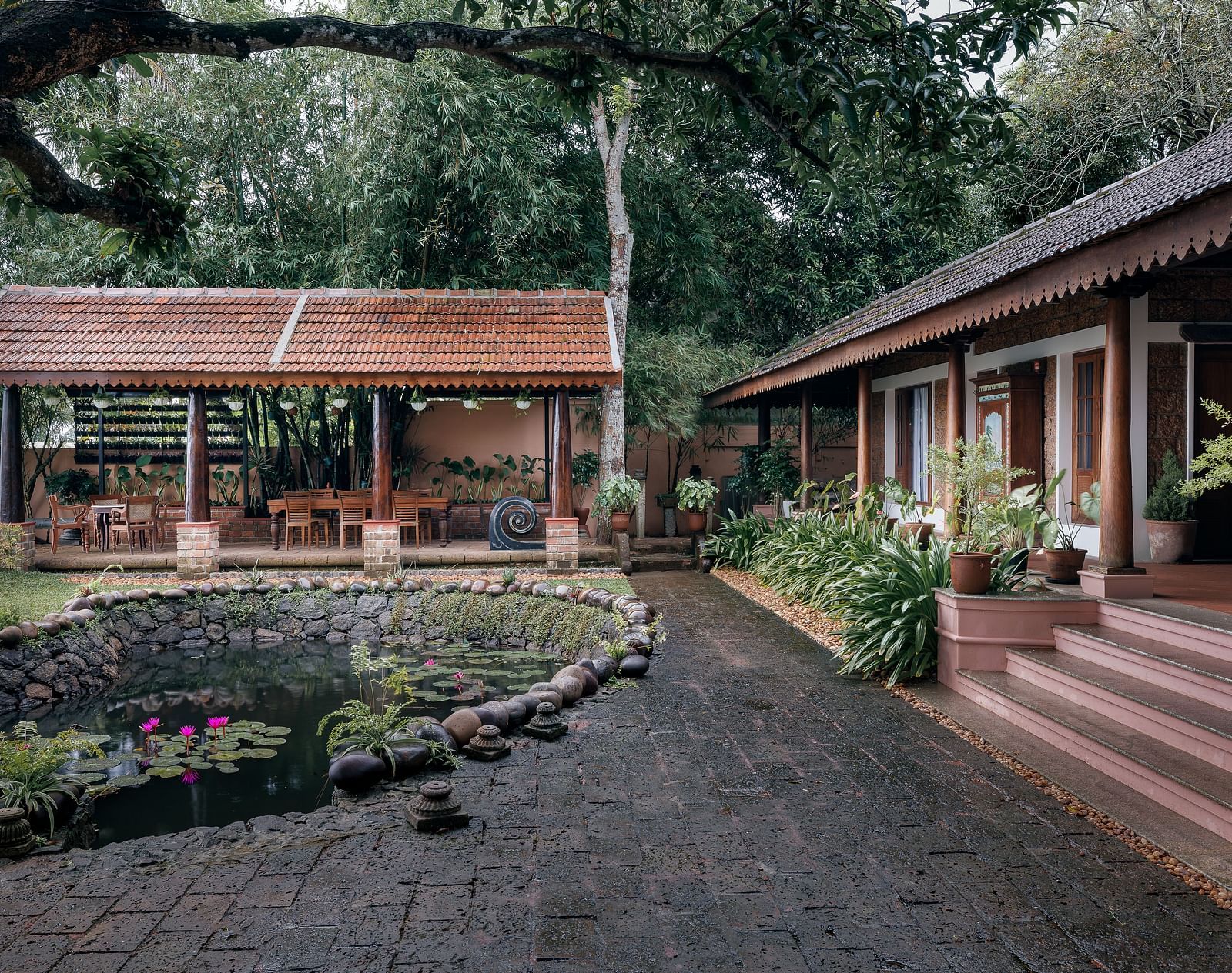 A facade of BluSalzz Villas - Muhamma Resort, Alleppey featuring the pond and the villa on the right and the restaurant in the background