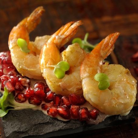 Cooked shrimp with pomegranate and microgreens.