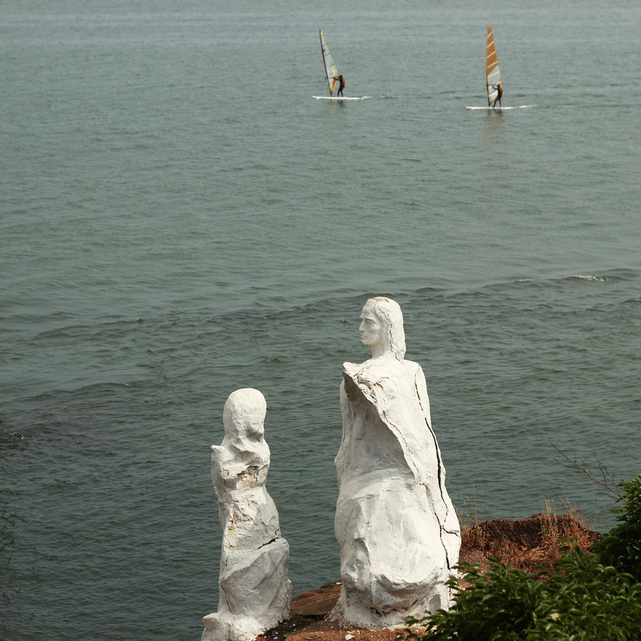 two statues near the banks of a river of Dona Paula with a river in view