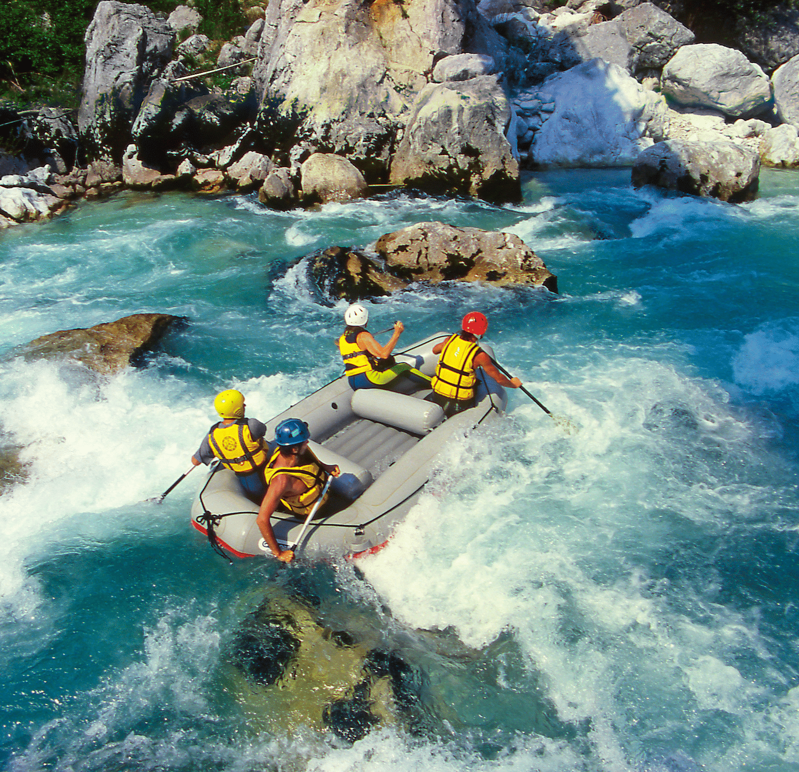 Group of people whitewater rafting on a river.