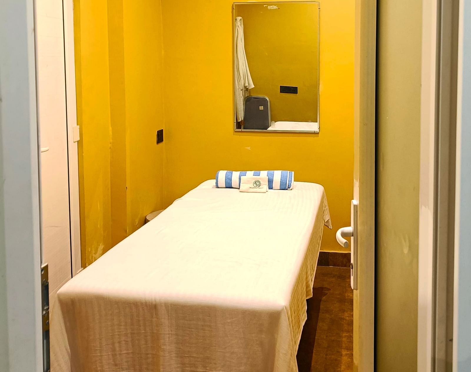 Spa room at DLS Forest Vines Resort as seen from the entrance, with a neatly made massage bed.