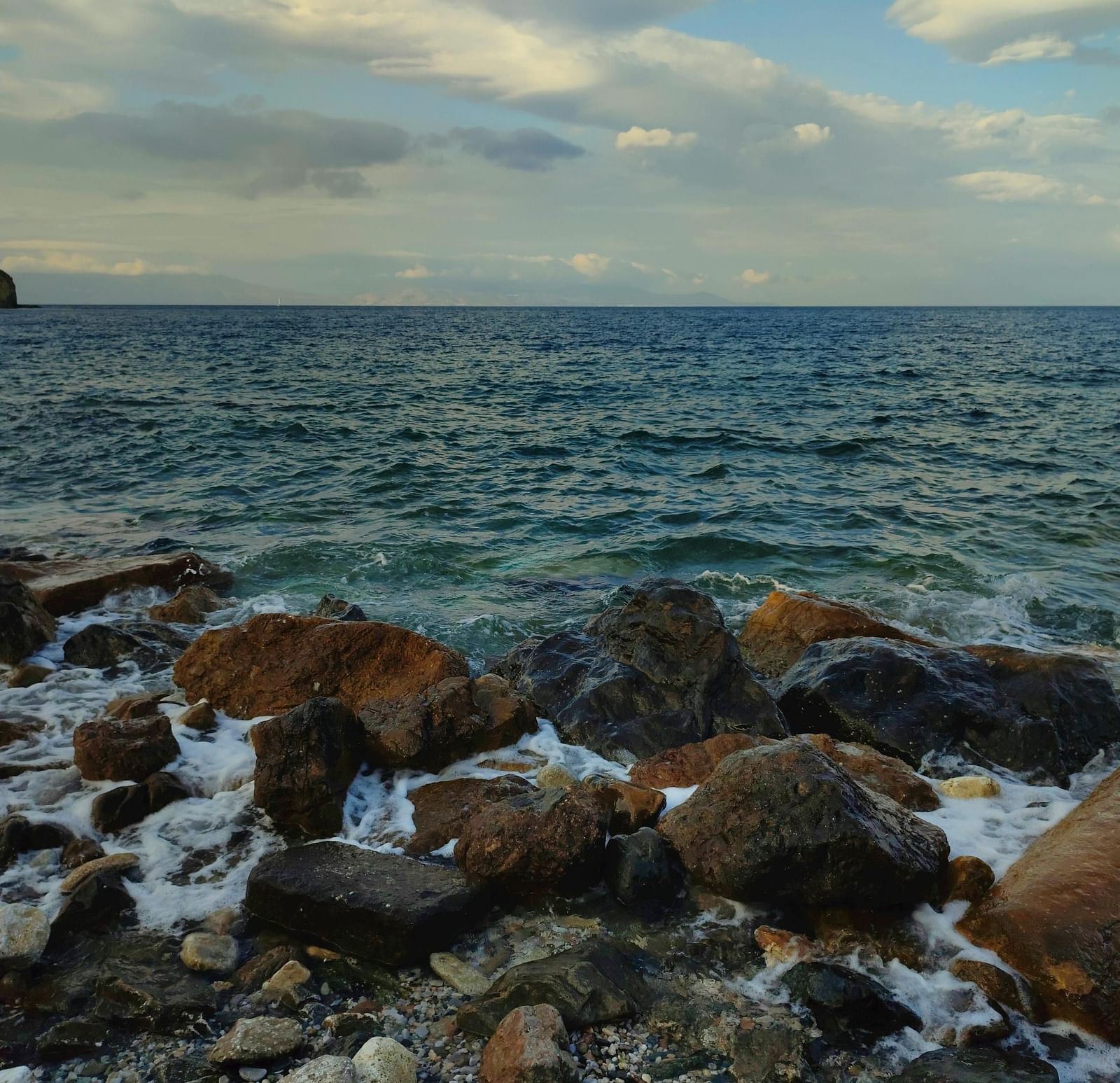 An image of a seaside where shores are hitting the rocks | Ocean Spray