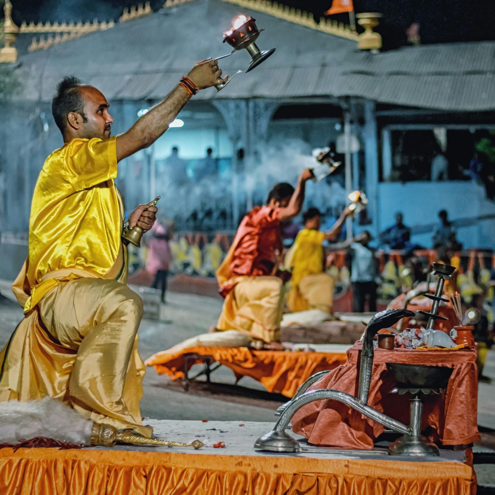 Priests worshipping in the open area decorated with flowers and other worship items.