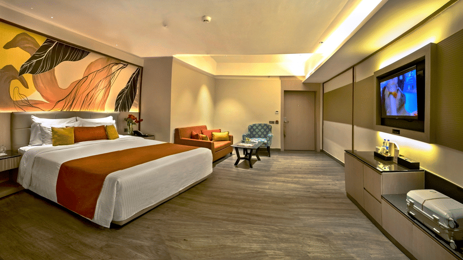 Spacious premium room with king bed, seating area and modern interiors at The Sonnet, Jamshedpur.