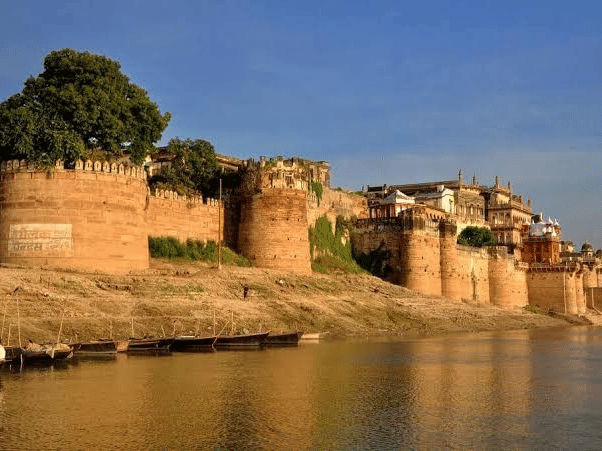 The stone walls and bastions of a fort situated on the bank of a river | HHI Varanasi