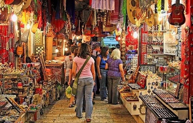 An image of a market with people shopping in antique and handcraft stores