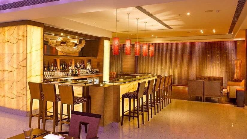 Stylish restaurant with a sleek bar, cosy seating, and ambient lighting – Hotel Hindusthan International, Kolkata.