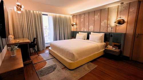 Spacious Bedroom with Modern Furniture and Artwork in Royal Suite at Pride Plaza Ahmedabad.