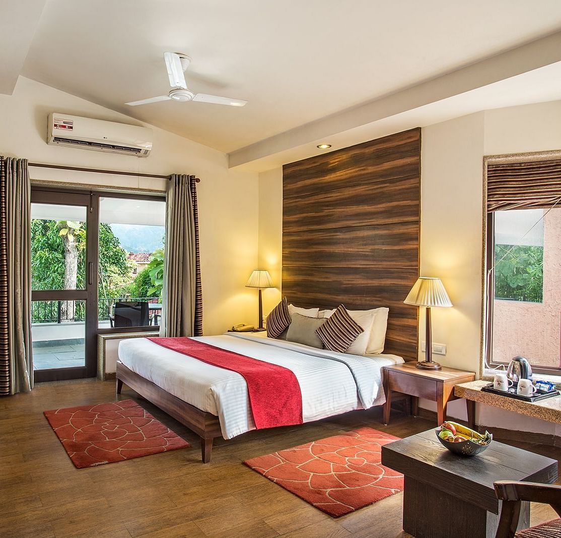 An image of a bedroom with king size bed, bedside table and lamp,  flat TV screen,  a cabinet , fan, and an open window - The Riverview Retreat, Corbett