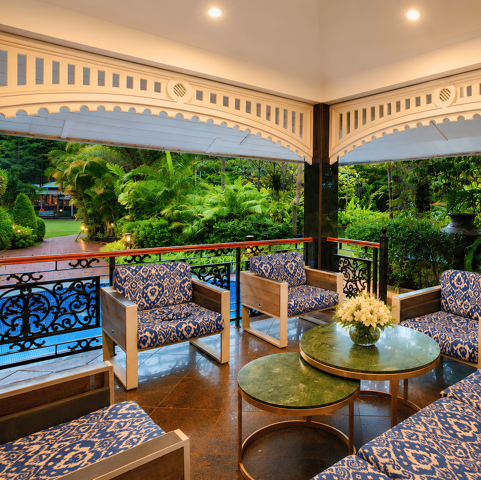 Gazebo seating with blue ikat armchairs, green marble tables and fretwork arches overlooking the pool and garden at MAYFAIR Oasis Resort & Convention, Jharsuguda.