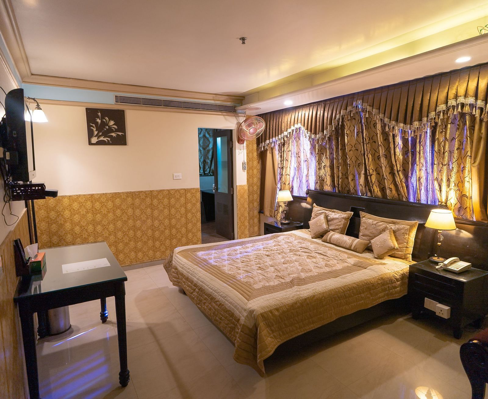 Queen Room featuring a bed, a desk, and a television. - Hotel Ashok Nagpur