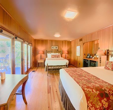 a room with ample of natural light coming from the huge windows featuring two comfortable double beds - Historic Tapoco Lodge