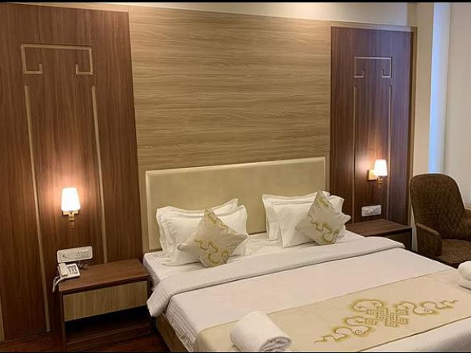 Overview of the Deluxe Room with a queen bed, side tables and lamps - Sumitel Gangtok