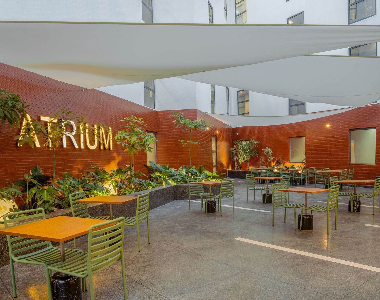 Atrium restaurant at The Pelican Hotel, Accra, featuring shaded seating and a contemporary courtyard vibe.