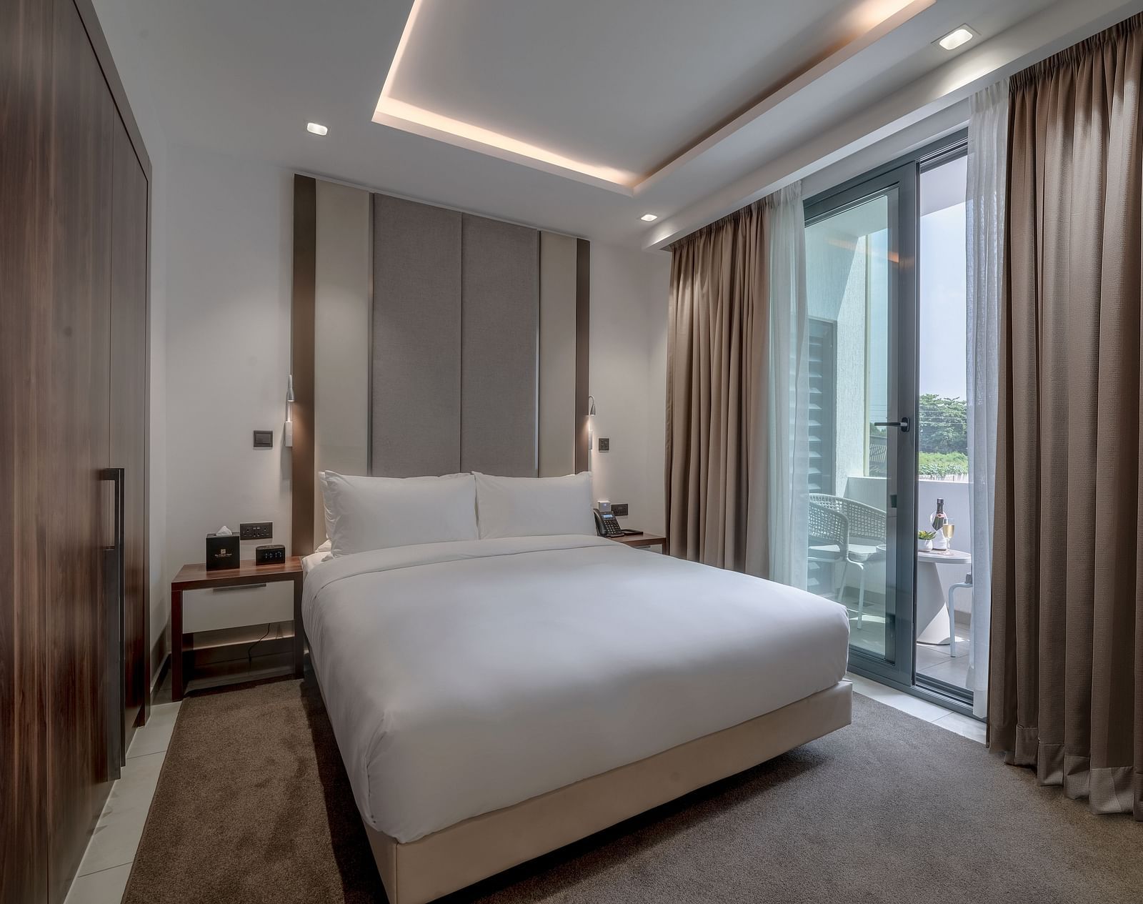 A spacious, well-lit Executive Suite featuring a king size bed and floor-to-ceiling windows - The Pelican Hotel, Accra - Place To Stay in Accra, Ghana, with Family.