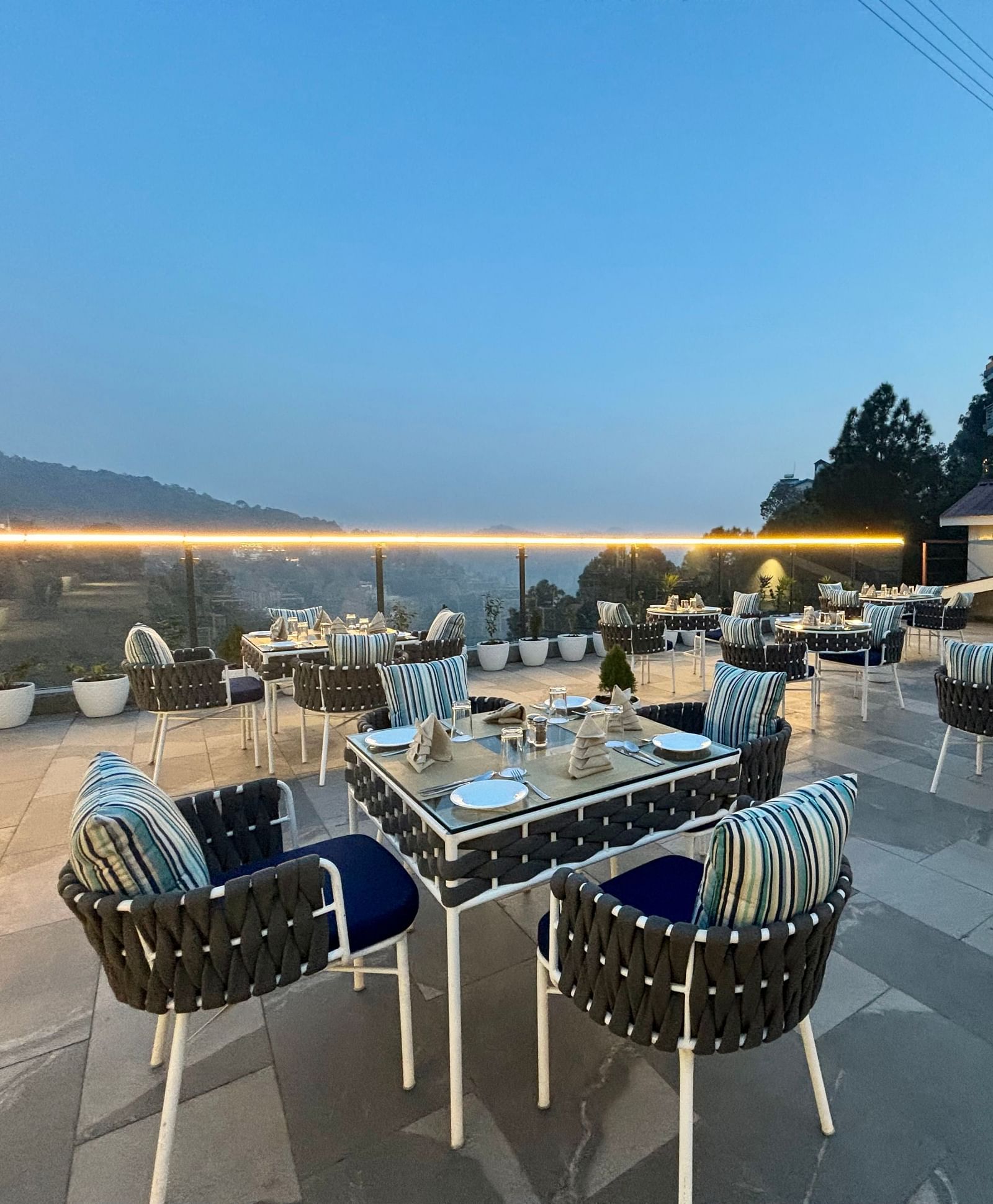 Outdoor dining area at twilight with neatly arranged tables and scenic views – ARNISA Boutique Hotel