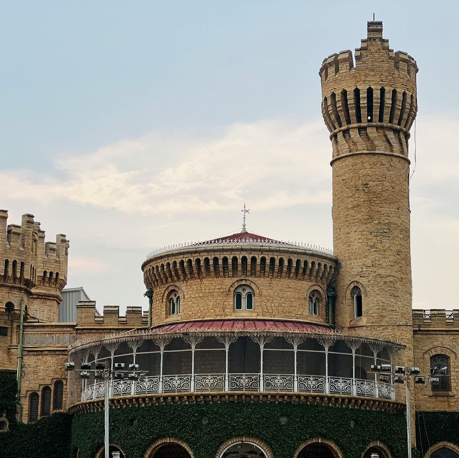A stunning view of Bangalore Palace, showcasing its Tudor-style architecture with towers and arched windows.