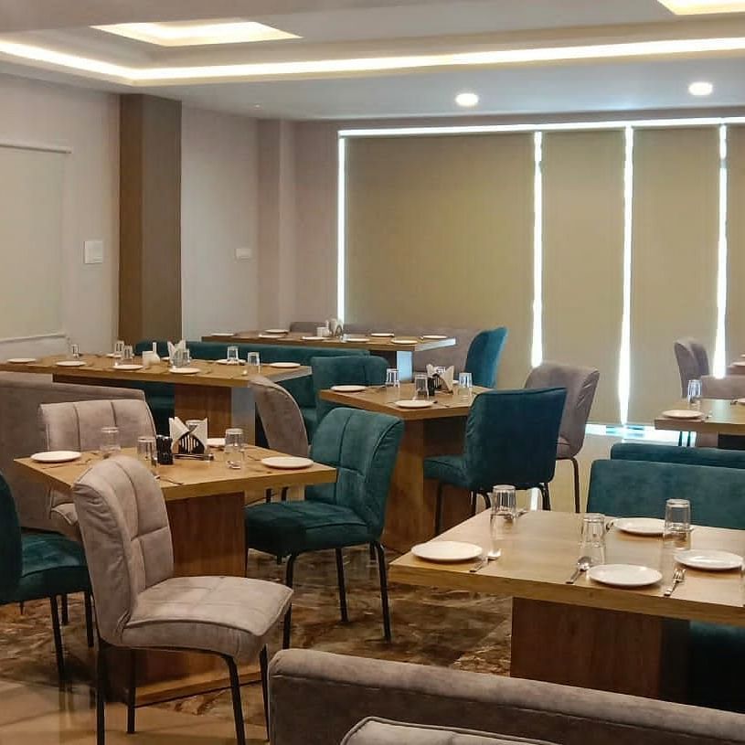 Dining area with blue and brown chairs at Hotel Mumbai House, Indore