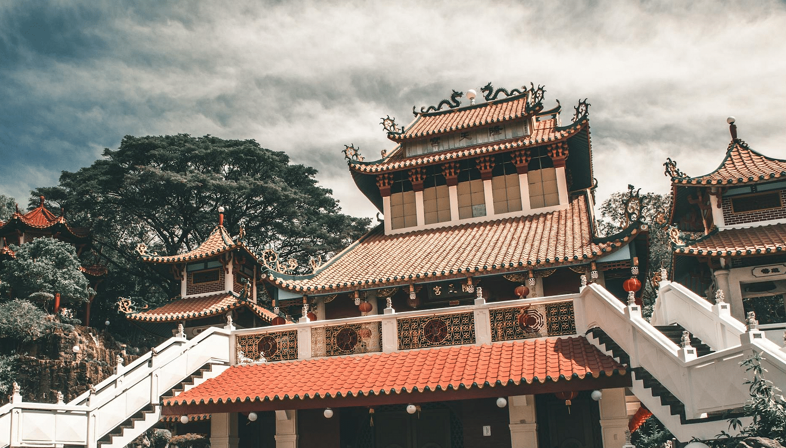 Image of a Buddhist temple with trees on the side.