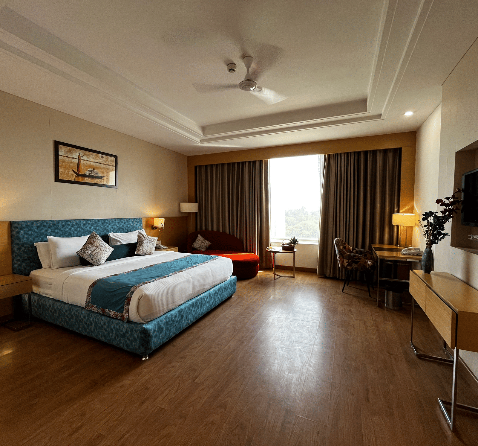 Guest room with king bed, seating space, television and window view at The Conway, Meerut