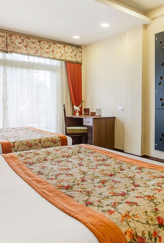 Family room at Summit Barsana Resort & Spa, Kalimpong with a double bed and a television