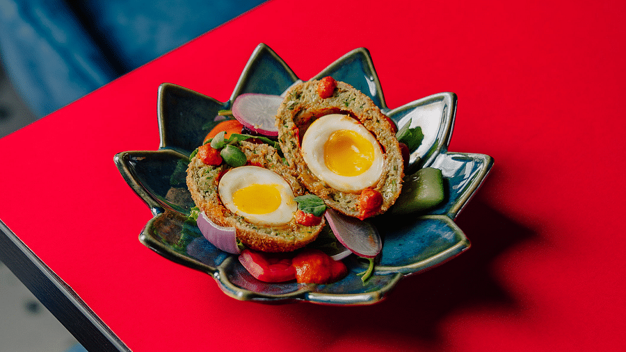 Delicious scotch eggs plated beautifully on a floral-shaped dish. | The Icon Select by Bhagini, Mahadevapura