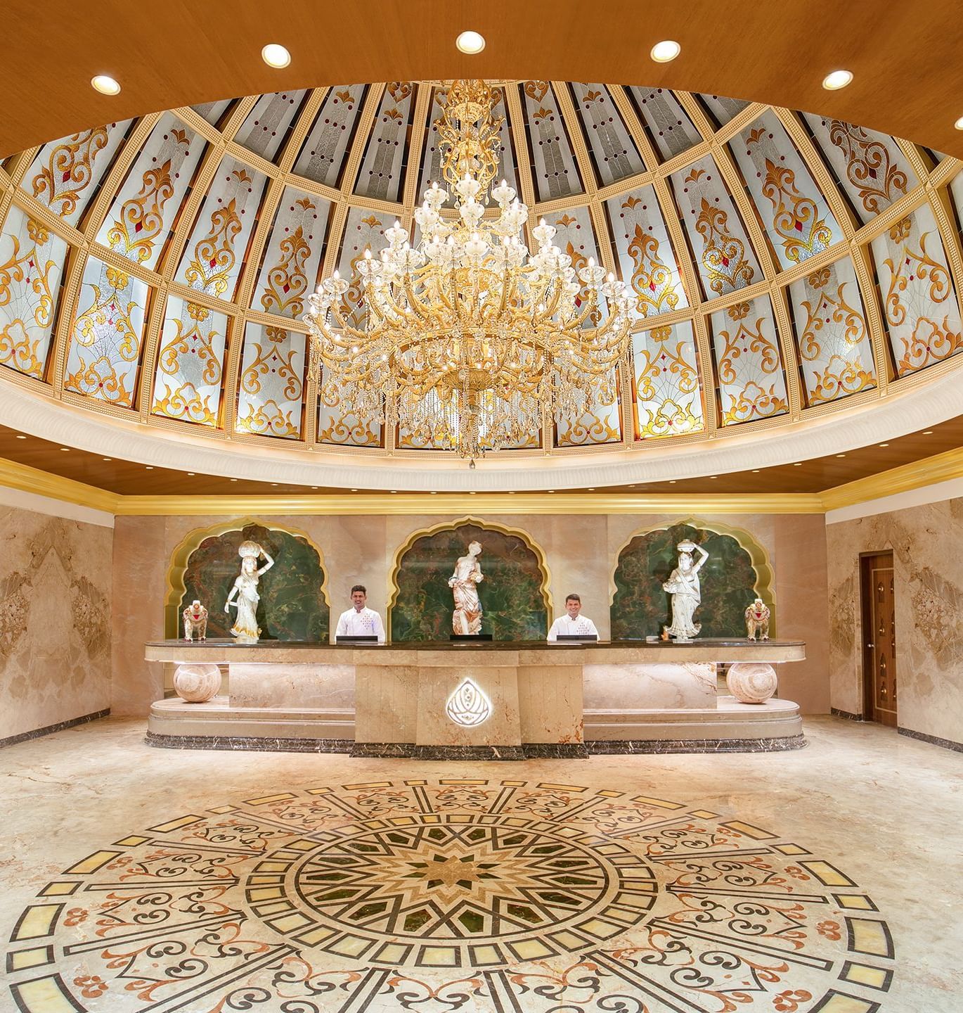 A reception area with a reception desk, receptionists and a giant chandelier - Kaldan Samudhra Palace