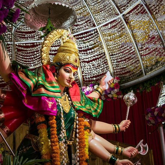 A close up shot of the idol Durga Maa inside a temple with the roof in view