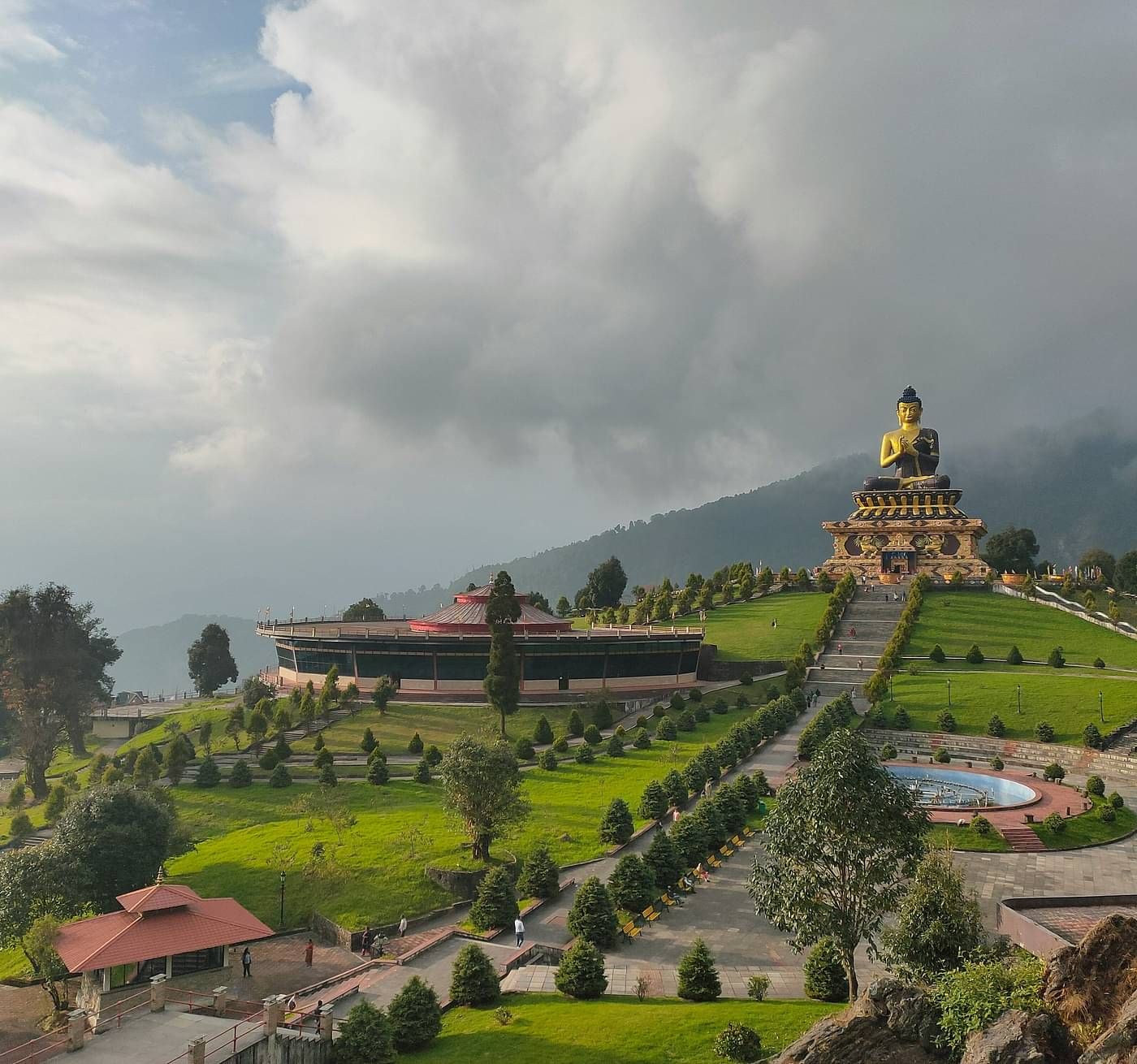 an image of a hill with trees and buildings in the distance