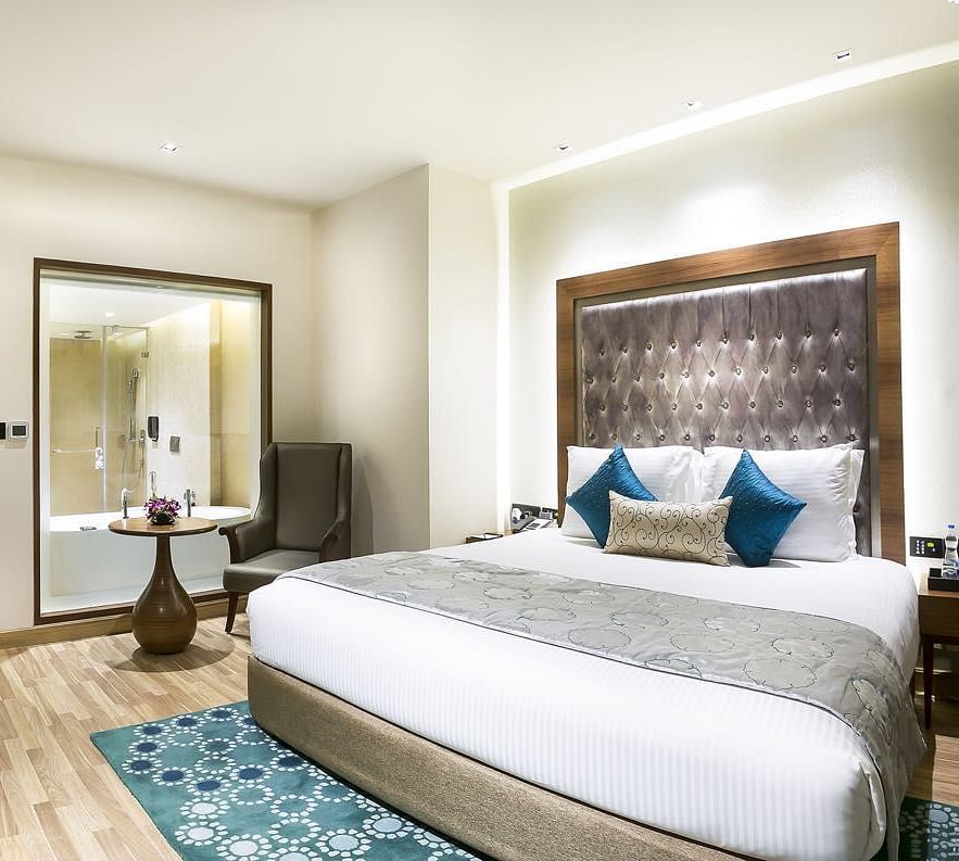 View of the king size bed of a Deluxe Suite at at Grand Chennai By GRT Hotels.